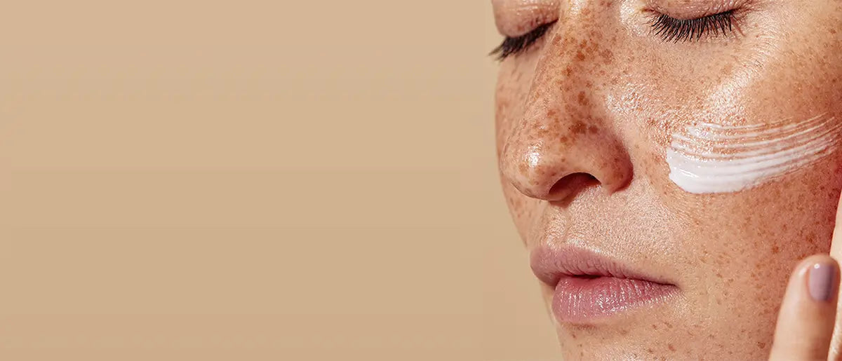 mujer aplicándose crema para la piel