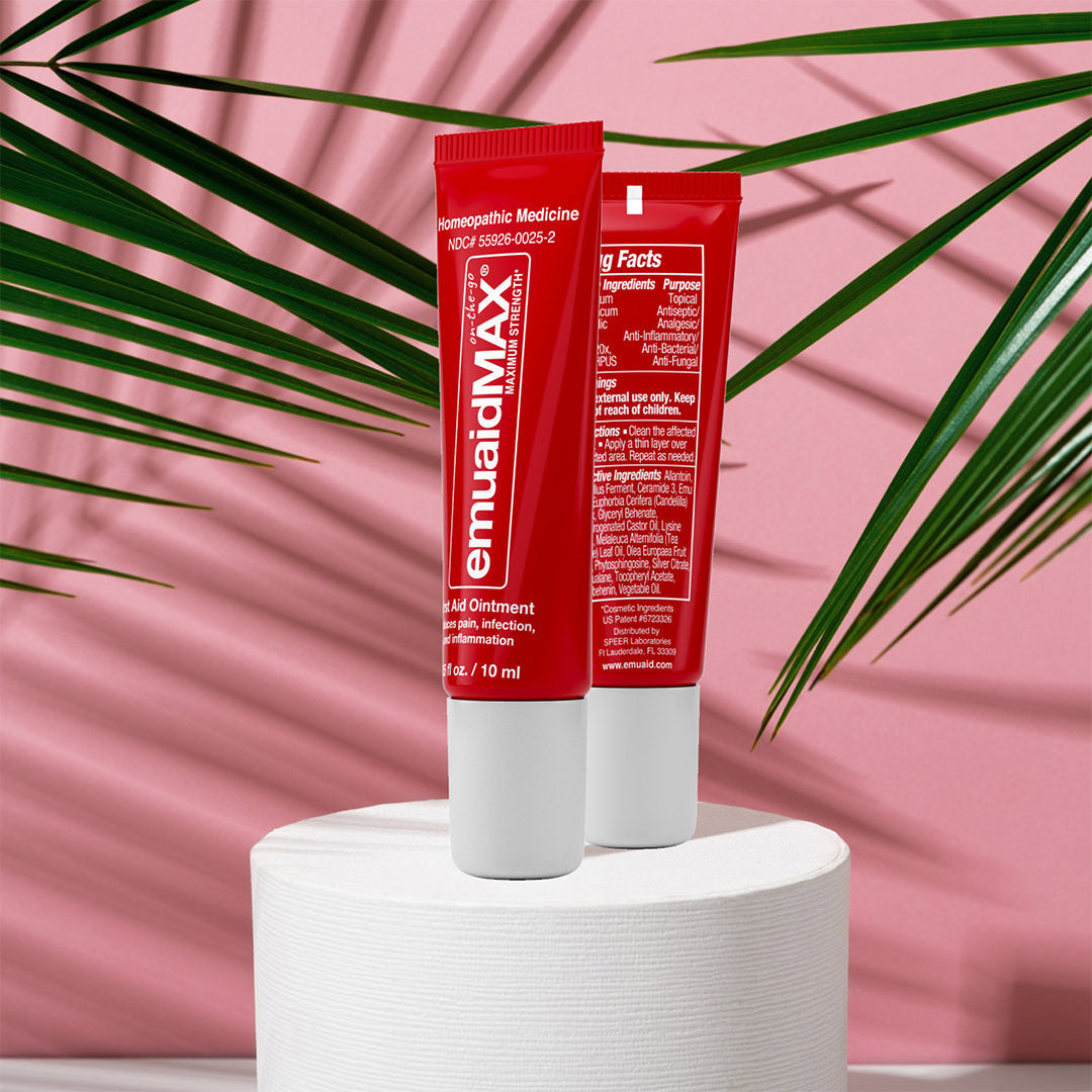 tubos rojos de pomada emuaidmax sobre fondo rosa